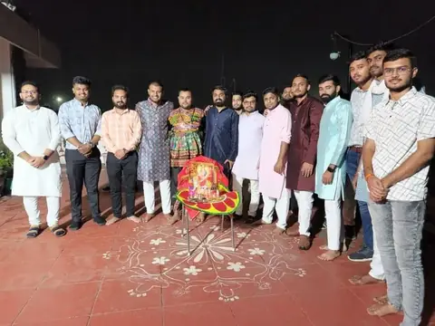 Male team members in ethnic wear at a Dussehra festival celebration with a decorated idol on a rooftop