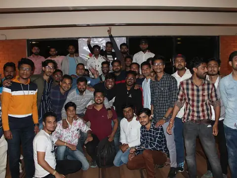 Large group of male students posing together at an evening event