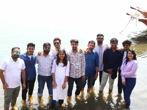 Team members posing together standing in shallow water on a team trip