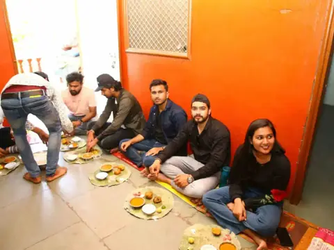 Team members seated on the floor sharing a traditional meal together
