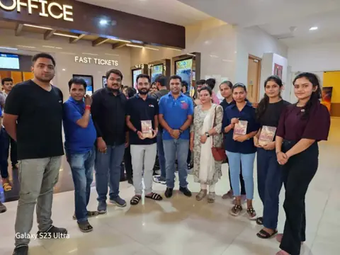Team members holding movie tickets at a cinema during a group outing