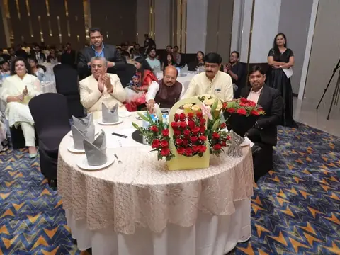 Guests of honor seated at a decorated table with flower bouquets at the anniversary event