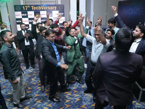 Men dancing energetically in front of the 17th TechVersary backdrop
